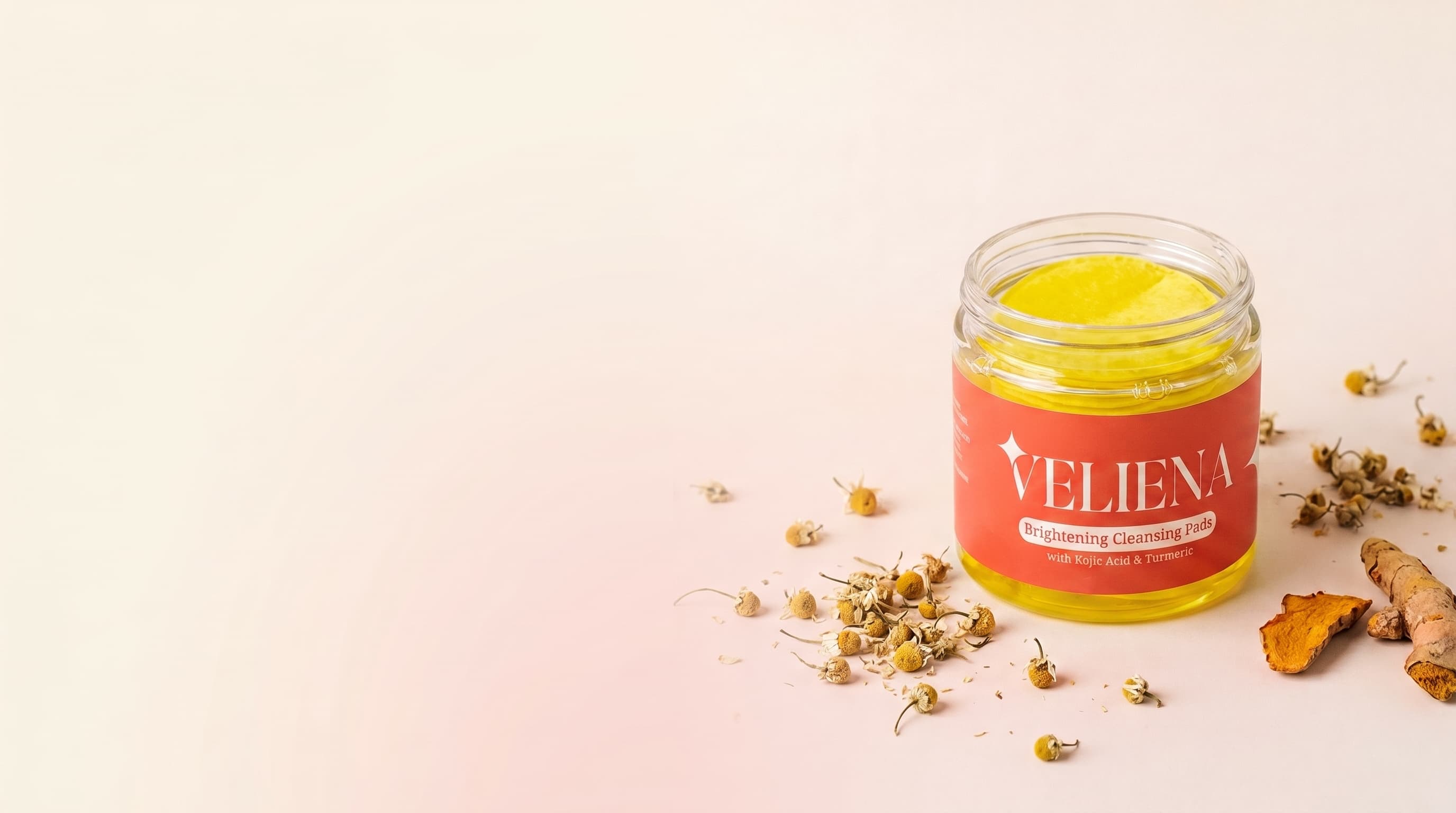 A jar of Veliena Brightening Cleansing Pads with chamomile flowers and fresh turmeric